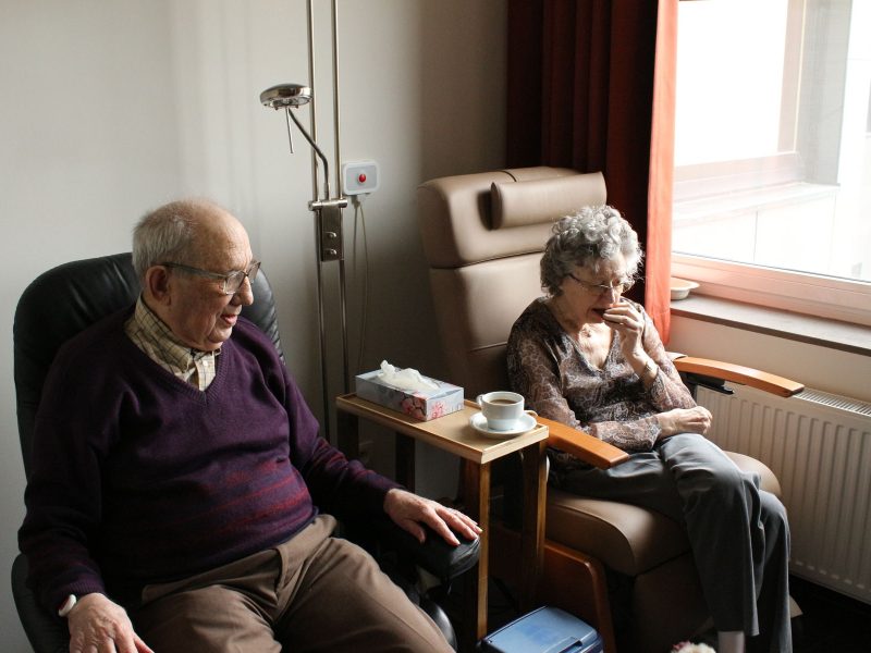 Elderly couple sitting in a dimly lit room
