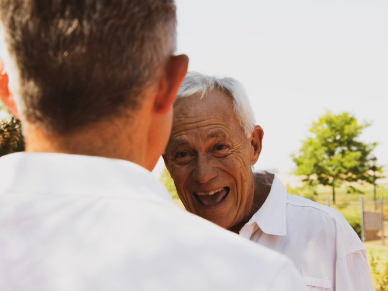 Elderly man in white shirt laughing